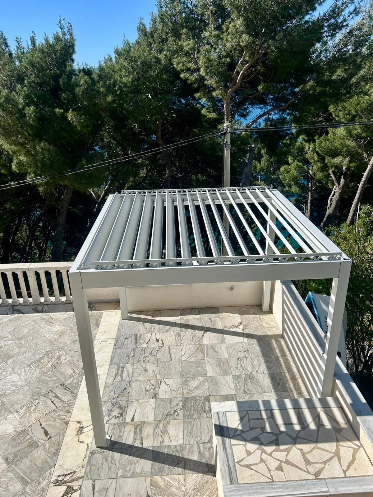 PergoMaxx pergola — bočna perspektiva instalacije na mramornoj terasi